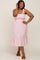 woman wearing a light pink smocked midi dress with tie straps and ruffle hem