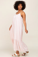 Woman with afro hair wearing a pink and white striped maternity maxi dress with spaghetti straps and white sandals