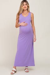 pregnant woman wearing a purple sleeveless maternity maxi dress and white sandals
