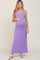 pregnant woman wearing a purple sleeveless maternity maxi dress and white sandals