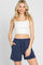 woman wearing white ribbed crop top and navy blue drawstring shorts against a white background