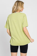 Back view of a woman wearing an oversized light green t-shirt and black biker shorts