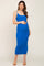 woman wearing a bright blue ribbed maternity dress and holding her baby bump