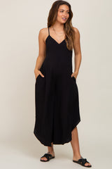 woman wearing a black sleeveless maternity jumpsuit with pockets and wide legs