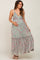 smiling pregnant woman wearing a green and pink floral print maternity maxi dress with ruffle details