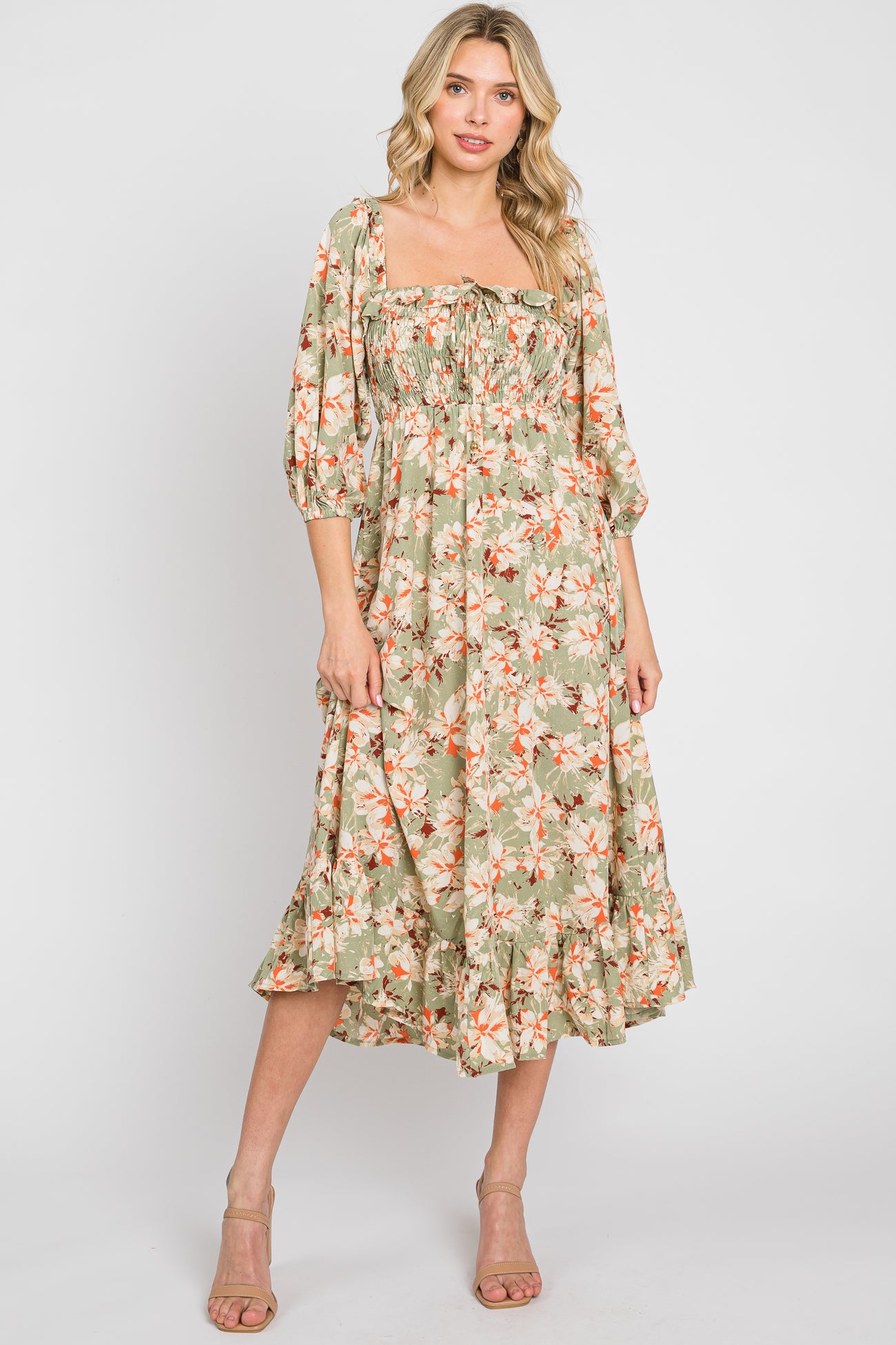 woman wearing a sage green floral midi dress with puff sleeves and smocked bodice