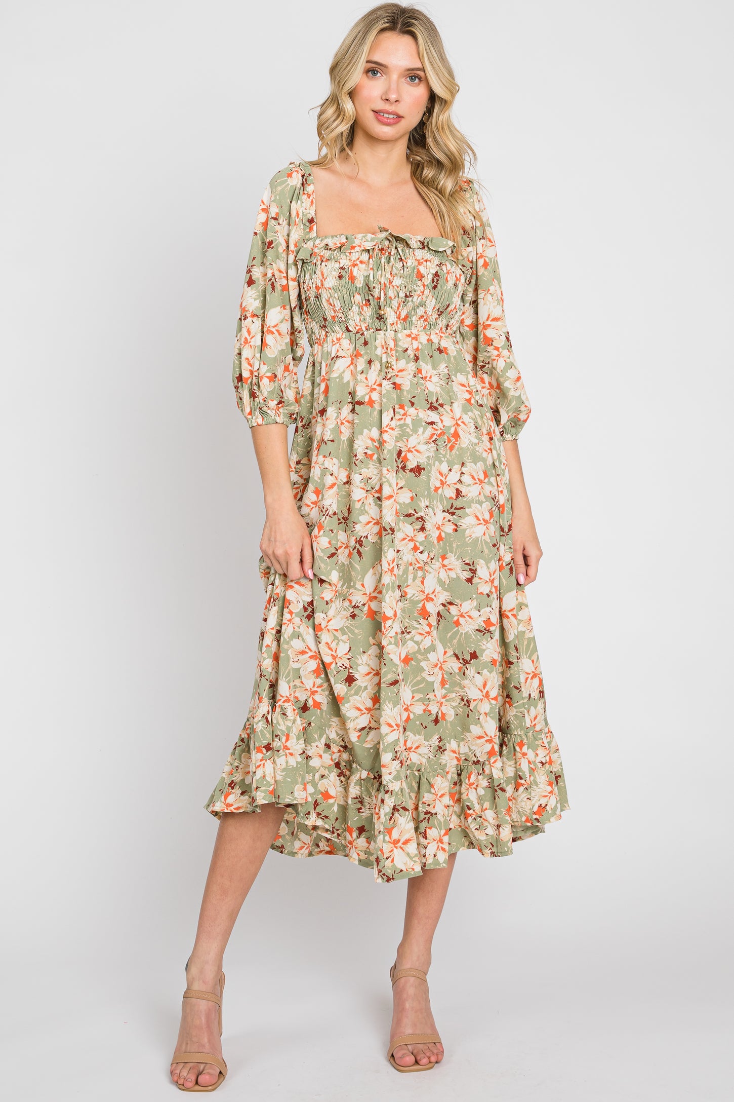 woman wearing a sage green floral midi dress with puff sleeves and smocked bodice