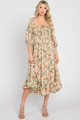woman wearing a sage green floral midi dress with puff sleeves and smocked bodice