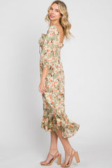 woman wearing a green floral midi dress with puff sleeves and a ruffled hem, standing sideways with a smile