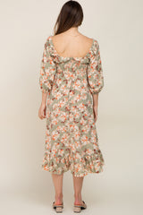 woman wearing a floral maternity dress with a smocked back and ruffled hem, showing her pregnant belly