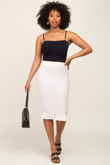 woman wearing black camisole and white smocked midi skirt with ruffle hem holding a black handbag