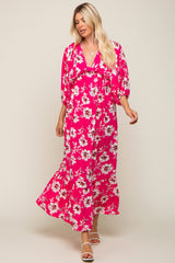 woman wearing a pink floral maxi dress with a v-neck and puff sleeves, standing in a relaxed pose