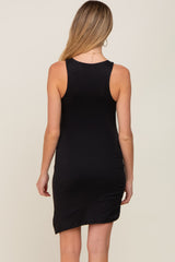 back view of a woman wearing a sleeveless black bodycon dress with an asymmetrical hemline