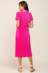Back view of a woman wearing a hot pink pleated midi dress with short sleeves and white wedge sandals