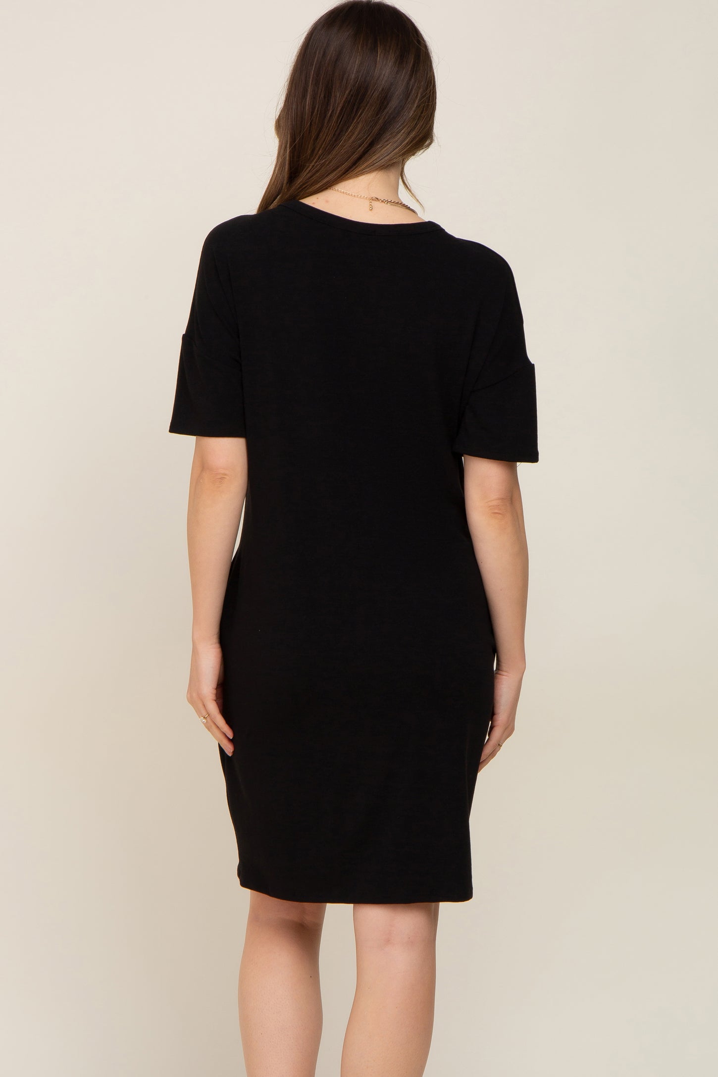 back view of a woman wearing a short sleeve black t-shirt dress