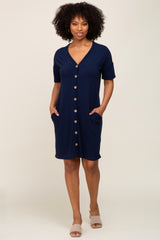 woman with afro hair wearing a navy blue button down short sleeve dress with pockets