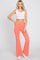 woman wearing white ribbed crop top and coral high waisted flare leggings with crossover waistband