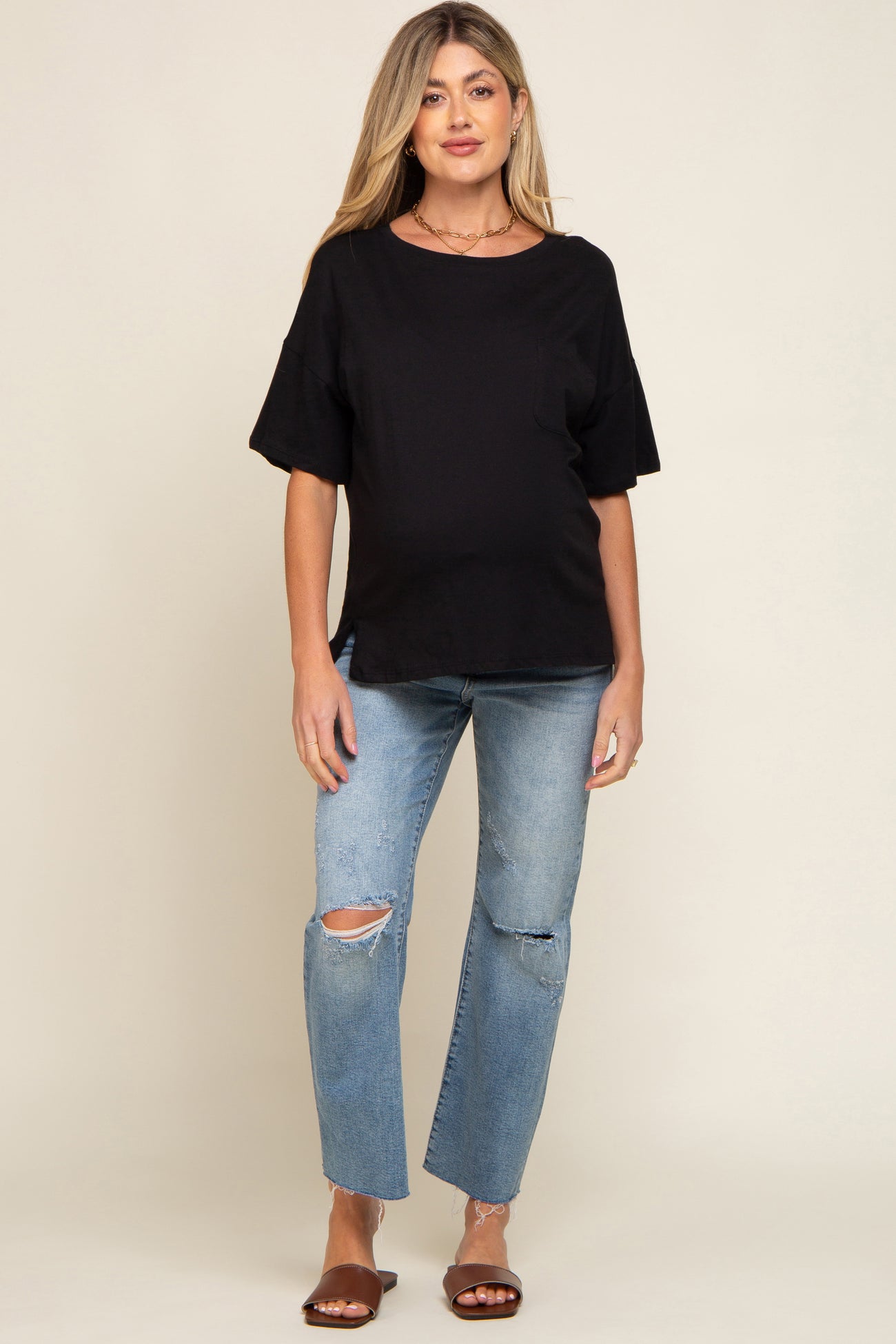 Pregnant woman wearing a black short sleeve maternity t-shirt and distressed blue jeans