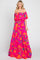 woman wearing a pink off-the-shoulder floral maxi dress with orange and teal patterns