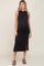 Pregnant woman wearing a sleeveless black maternity midi dress with a side slit and black sandals