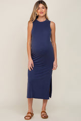 pregnant woman wearing a navy blue sleeveless maternity midi dress with side slits and brown sandals