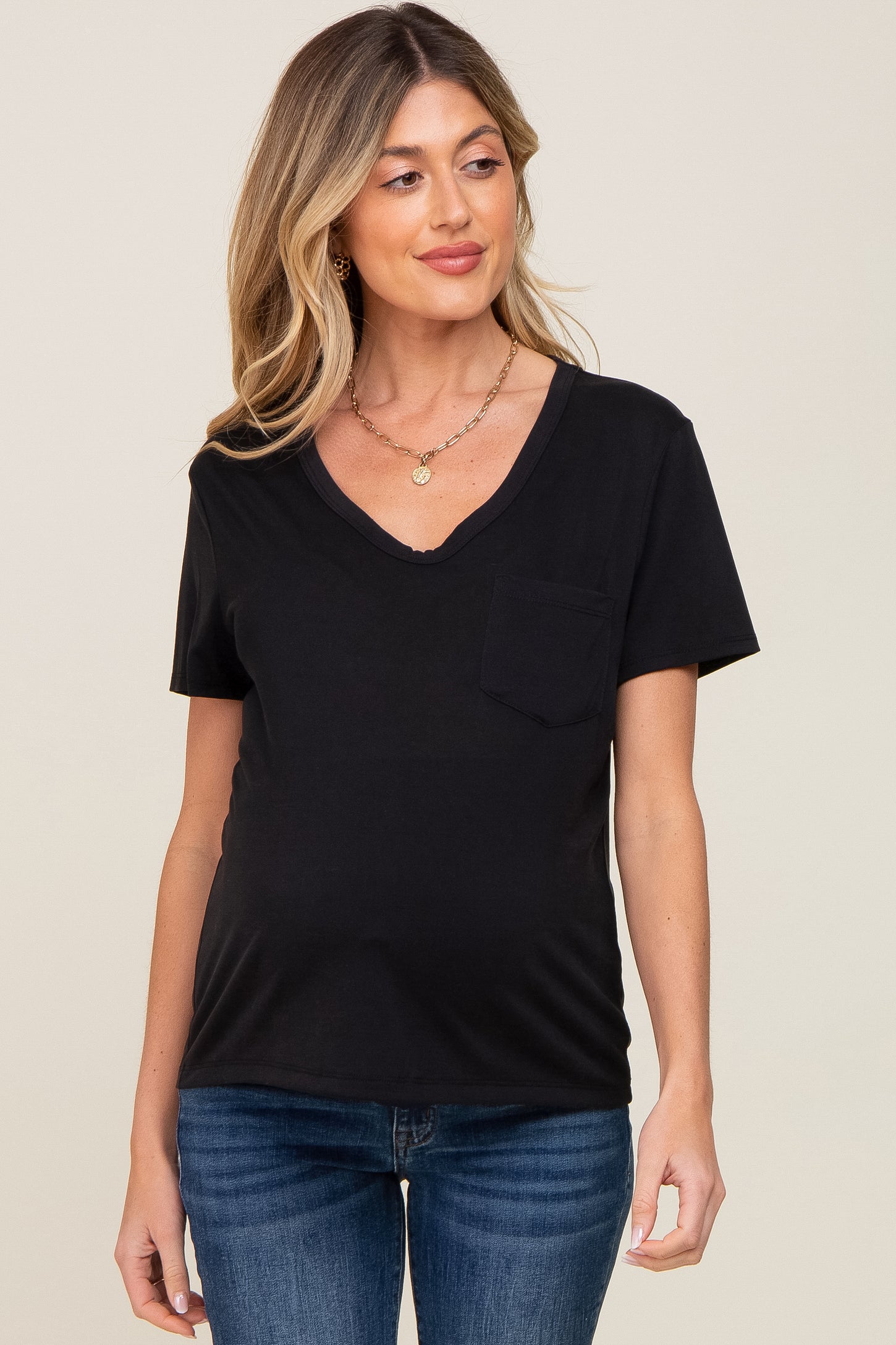 Woman wearing a black v-neck maternity t-shirt with a front pocket and blue jeans