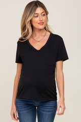 Woman wearing a black v-neck maternity t-shirt with a front pocket and blue jeans