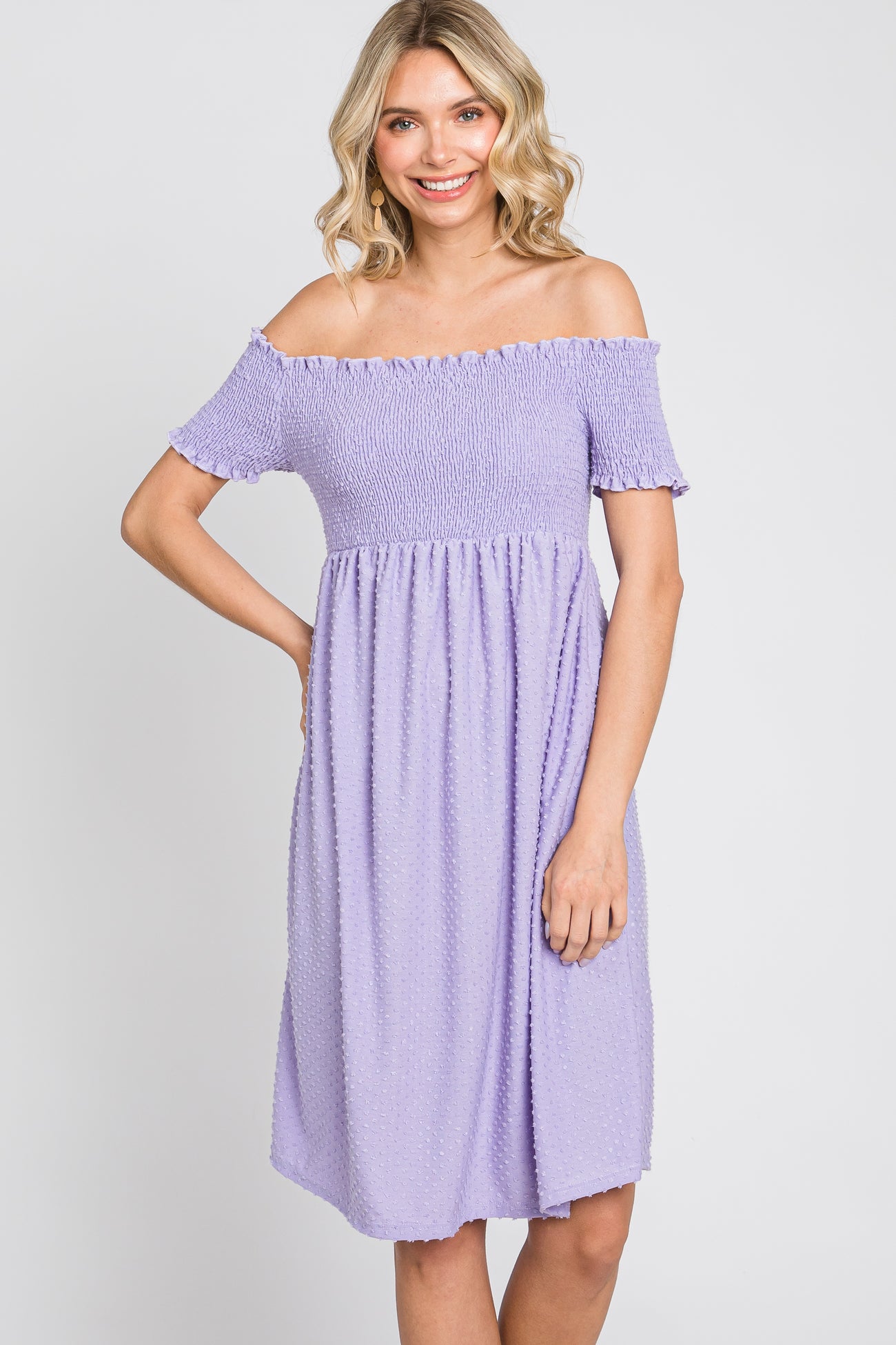 woman wearing a lavender off-the-shoulder smocked dress with swiss dot fabric