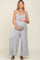 Pregnant woman wearing a grey sleeveless maternity jumpsuit with wide legs and tie straps