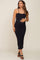 pregnant woman wearing a black ribbed maternity midi dress with spaghetti straps and black sandals