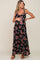 Pregnant woman wearing a black floral maternity maxi dress with tie straps and brown sandals