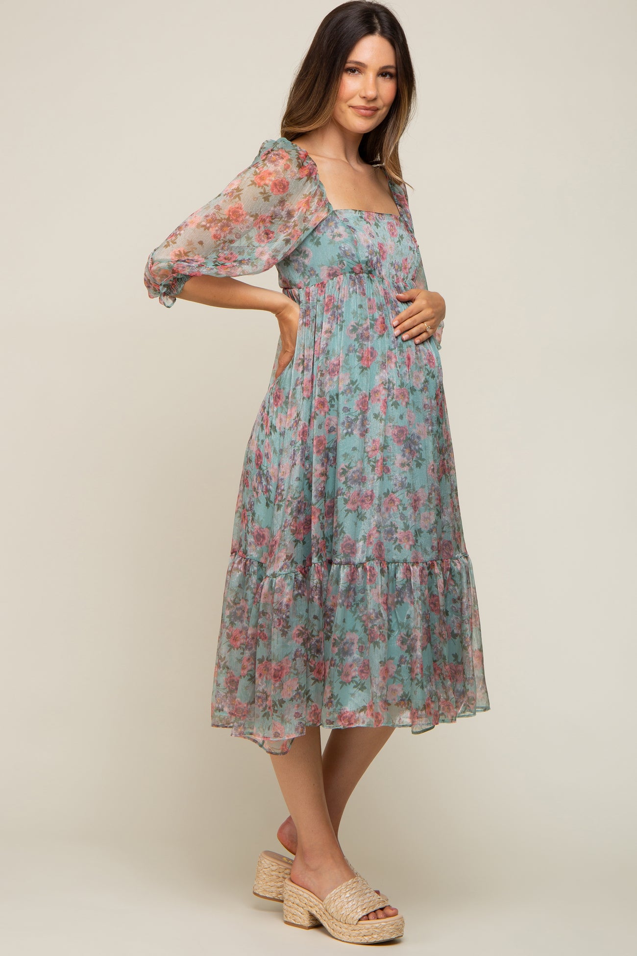 pregnant woman in a light blue floral maternity midi dress with puff sleeves and woven platform sandals