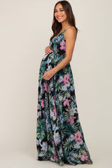 woman wearing a black floral maternity maxi dress and holding her baby bump