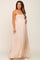 Pregnant woman in a light pink smocked maternity maxi dress with swiss dot pattern and tiered skirt