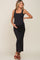 pregnant woman wearing a black ribbed sleeveless maternity maxi dress and brown sandals