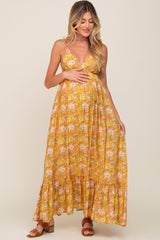 pregnant woman in yellow floral maternity maxi dress with spaghetti straps and ruffled hem