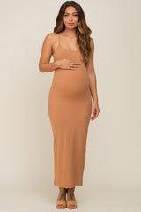 woman wearing a tan ribbed maternity maxi dress and cradling her baby bump