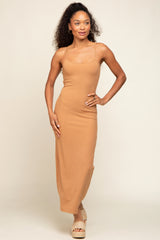 woman wearing a tan ribbed maxi dress with spaghetti straps and posing with one hand on her hip