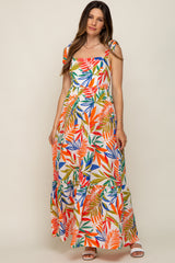 woman wearing a multicolor floral print maternity maxi dress with ruffled tiers and tie straps