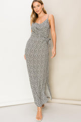 woman wearing a black and white floral print wrap maxi dress with spaghetti straps and side slit
