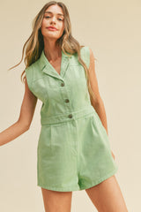 woman wearing a light green sleeveless romper with a collared neckline and button details