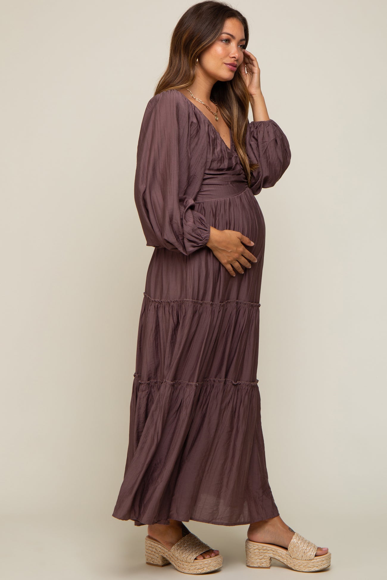 pregnant woman in a mauve long sleeve tiered maternity maxi dress and platform sandals