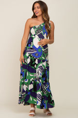 woman wearing a colorful one-shoulder maternity maxi dress with a tiered skirt and abstract patterns