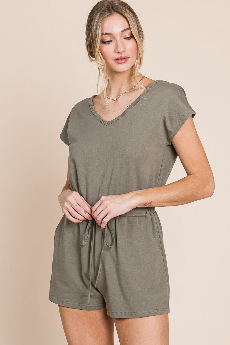 woman wearing olive green v-neck short sleeve romper with drawstring waist and pockets