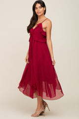 woman wearing a burgundy swiss dot ruffle midi dress with spaghetti straps and tan high heels