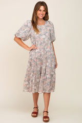 woman wearing a grey floral tiered midi dress with puff sleeves and brown platform sandals