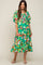 woman wearing a vibrant green floral maternity dress with puff sleeves and a tiered skirt, showcasing a baby bump