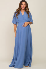 pregnant woman wearing a light blue short sleeve maternity maxi dress with a smocked waist