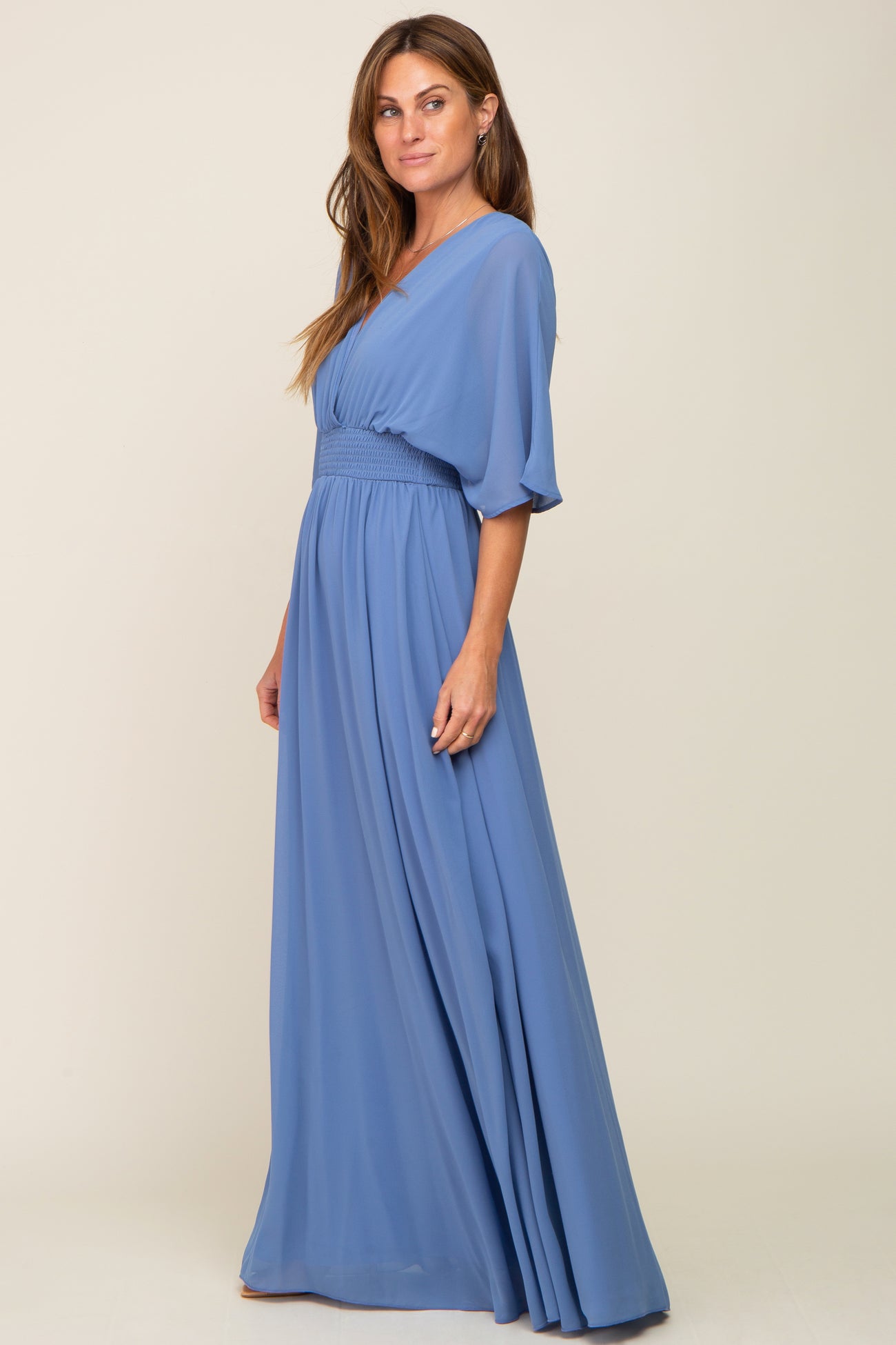 woman wearing a light blue v-neck maxi dress with flutter sleeves and a smocked waist