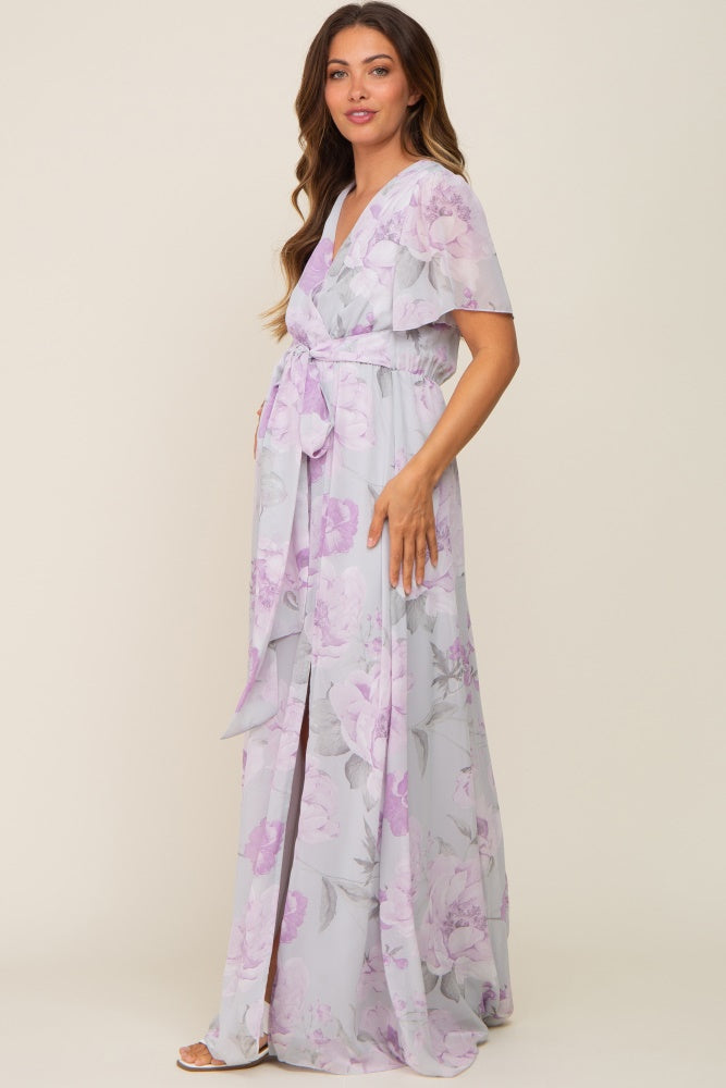 Woman wearing a light purple floral maternity maxi dress with short sleeves and a waist tie